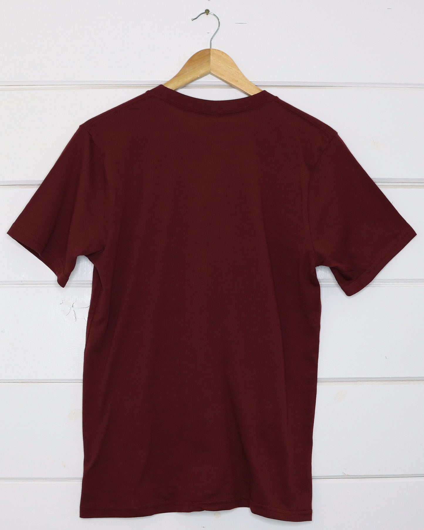 Maroon unisex t-shirt with bicycle riding cactus illustration on front, back