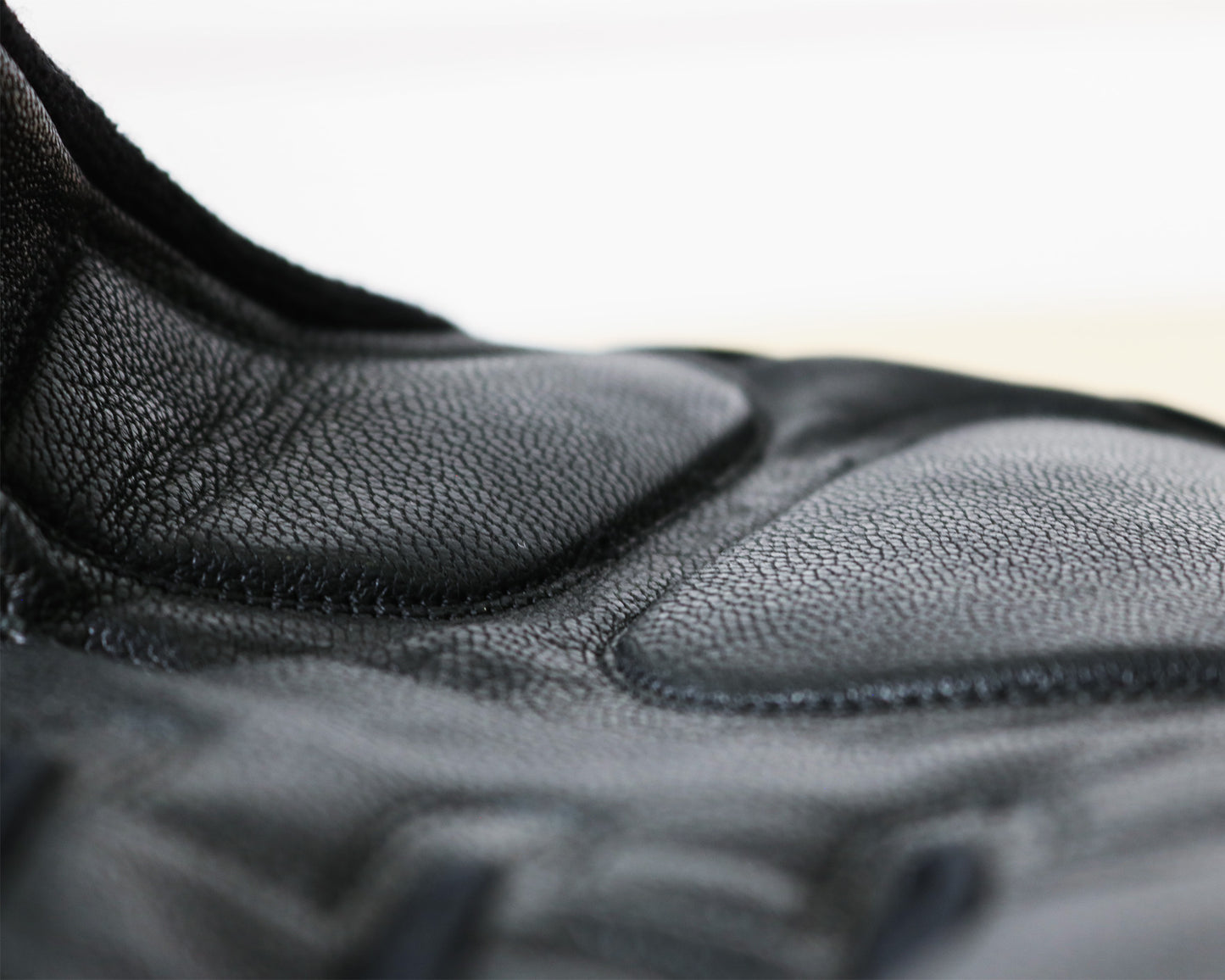 Padded, breathable mountain biking gloves made with goat leather and knitted yarn. Close up of palm material