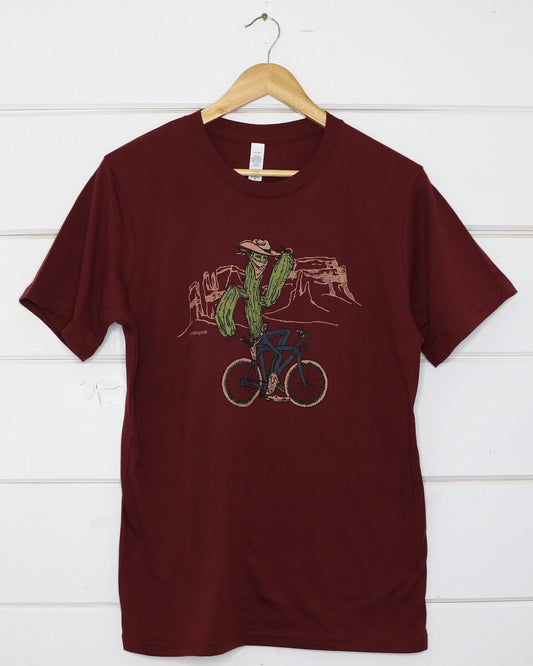 Maroon unisex t-shirt with bicycle riding cactus illustration on front