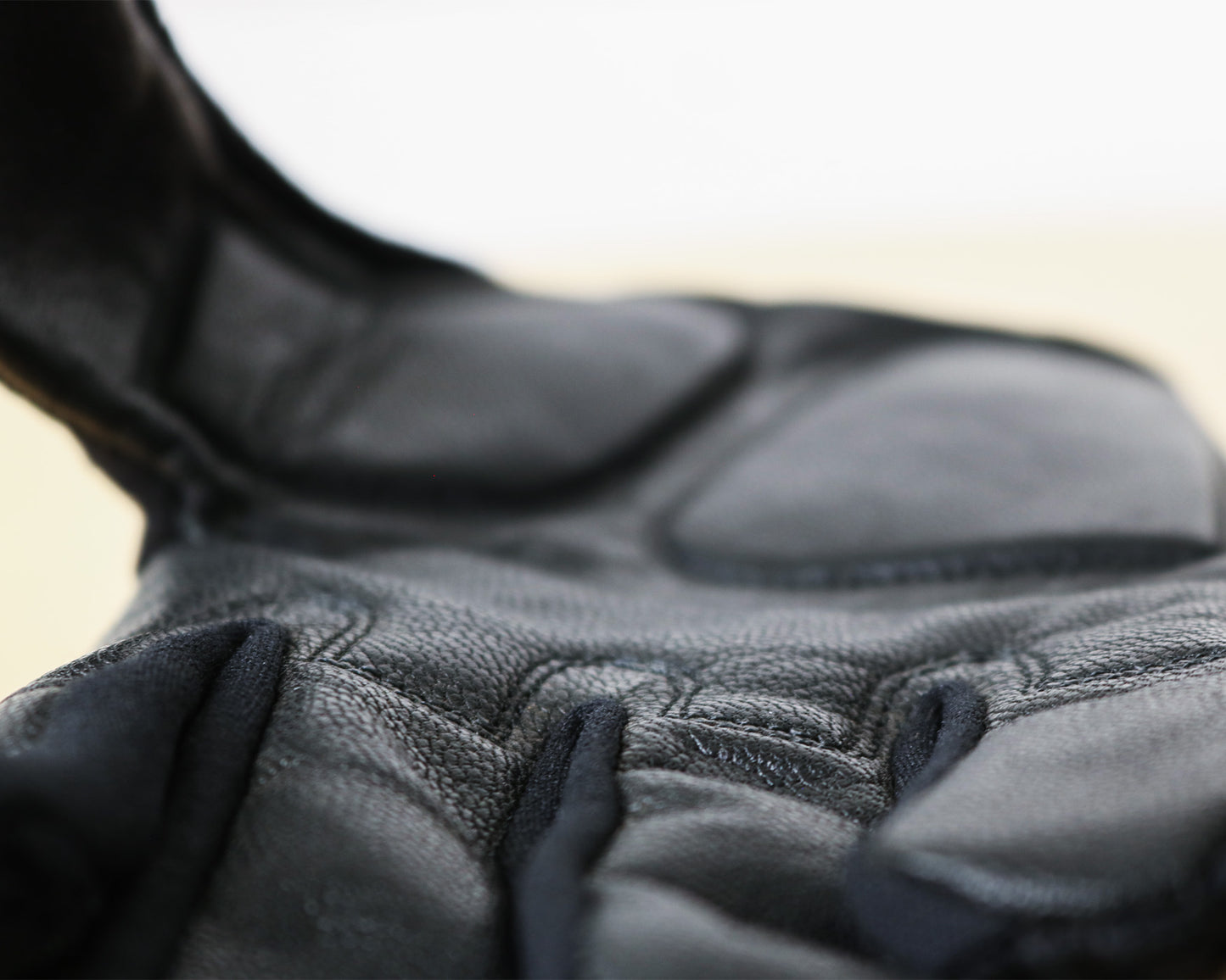 Padded, breathable mountain biking gloves made with goat leather and knitted yarn. Close up of palm material